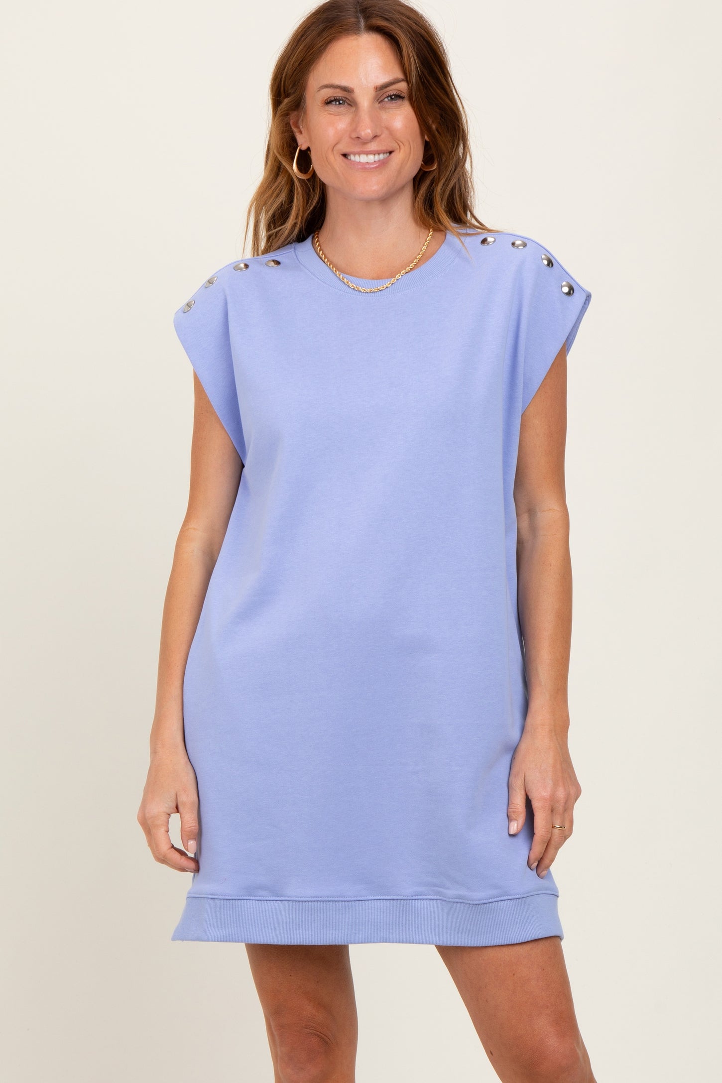 woman wearing a lavender oversized sweatshirt dress with decorative buttons on the shoulders