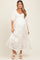 woman wearing a cream floral print maternity maxi dress with puff sleeves and a visible baby bump