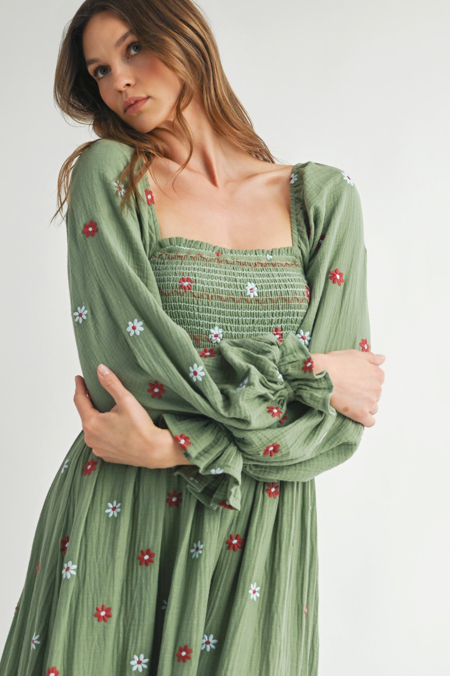 woman wearing a green floral smocked maxi dress with long puff sleeves and a square neckline