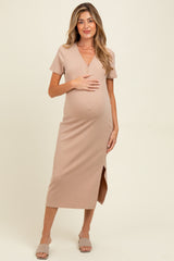 woman wearing a beige ribbed maternity dress with a v-neck and side slit, holding her baby bump