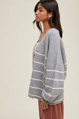 woman wearing a gray striped cardigan with a relaxed fit and deep v-neck, styled with a neutral top and corduroy pants