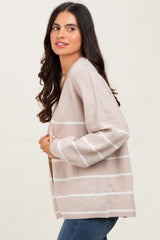 woman wearing a beige striped cardigan with long sleeves and a relaxed fit, posed sideways with a slight smile