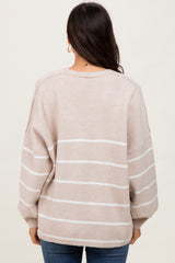 woman wearing a beige and white striped oversized sweater with balloon sleeves, viewed from the back