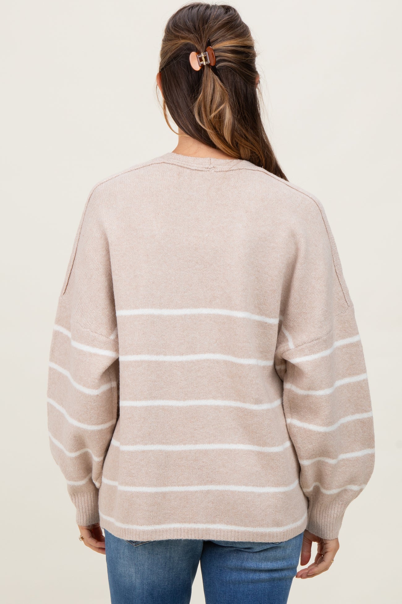 woman wearing a light beige striped maternity sweater with balloon sleeves, shown from the back