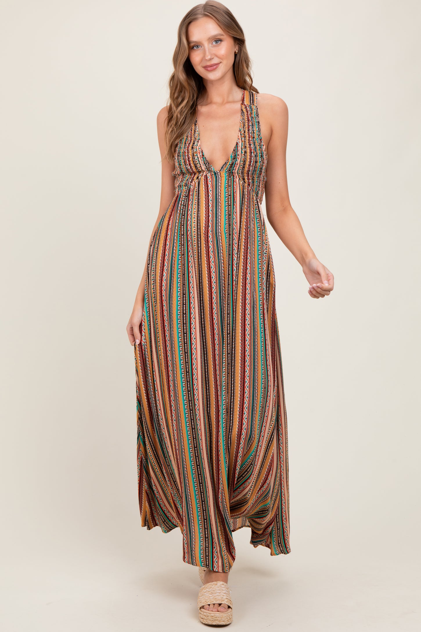 woman wearing a colorful patterned maxi dress with a deep V-neckline and braided straps