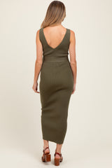 woman wearing an olive green ribbed maternity dress with a deep v-back, showcasing a baby bump