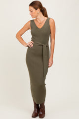 woman wearing an olive green ribbed sleeveless maxi dress with a tie waist and brown knee-high boots