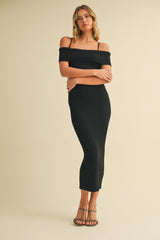 woman wearing a black ribbed off-the-shoulder midi dress with spaghetti straps and strappy heels