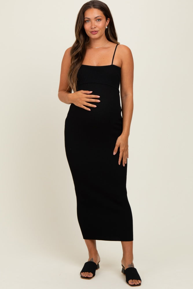 woman wearing a black ribbed maternity dress with adjustable straps and a visible baby bump