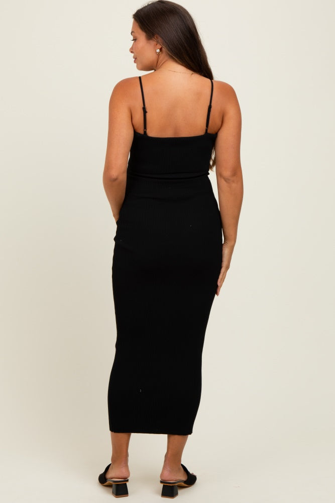 woman wearing a black ribbed maternity maxi dress with thin straps, showing a fitted silhouette from the back