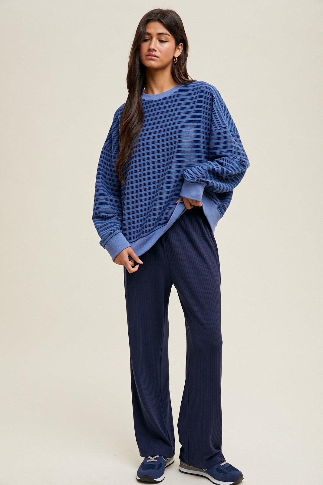 woman wearing a blue striped oversized sweater with long sleeves and navy ribbed wide-leg pants