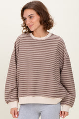 woman wearing a brown striped oversized sweatshirt with beige cuffs and hem