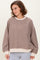 woman wearing a brown striped oversized sweatshirt with beige cuffs and hem