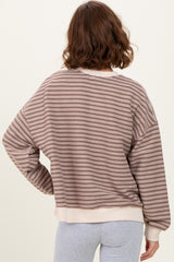 woman wearing a brown and cream striped oversized sweater, view of the back with relaxed fit and ribbed hem