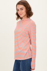 woman wearing a striped long sleeve top in orange and white with a rounded neckline and relaxed fit