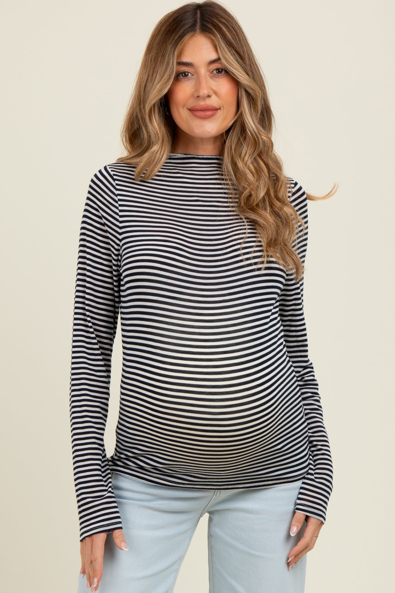 woman wearing a black and white striped maternity top and showing her baby bump