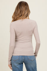 woman wearing a light beige long sleeve maternity top with a fitted style and back view, paired with blue jeans