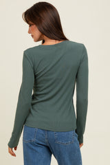 woman wearing a dark green long sleeve ribbed top, seen from the back with casual blue jeans