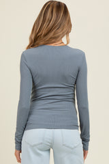 woman wearing a light blue long sleeve maternity top, viewed from the back, paired with light blue jeans
