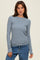 woman wearing a light blue long sleeve ribbed top and blue jeans