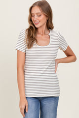 woman wearing a cream striped short sleeve top with a scoop neckline and light blue jeans