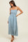 woman wearing a blue and white patterned maxidress with smocked bodice and spaghetti straps