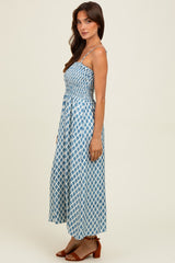 woman wearing a blue and white patterned maxi dress with spaghetti straps and a smocked bodice
