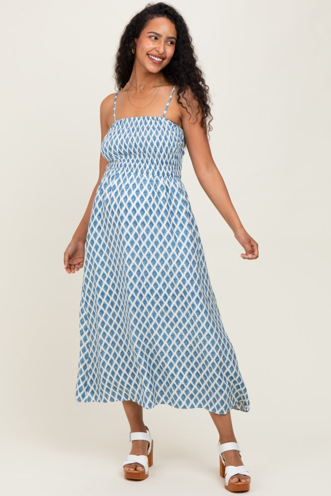 woman wearing a blue and white patterned maternity dress with adjustable straps and a flowing skirt, showcasing her baby bump