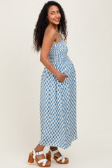 woman wearing a blue and white patterned maternity maxi dress and showing her baby bump