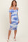 woman wearing a floral off-the-shoulder midi dress in blue and white with a fitted silhouette