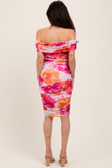 woman wearing a floral off-the-shoulder maternity dress with ruching and a fitted silhouette