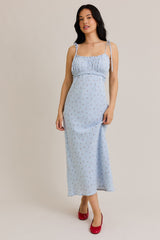 woman wearing a light blue floral maxi dress with adjustable straps and gathered bodice