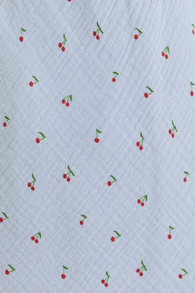 light blue fabric with a subtle cherry print in red and green
