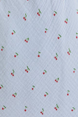 light blue fabric with a subtle cherry print in red and green