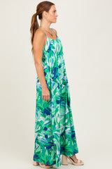 woman wearing a bright green floral maxi dress with a fitted bodice and flowy skirt, styled with a side view