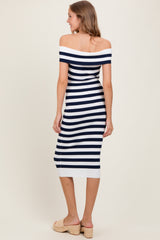 woman wearing a navy and white striped off-the-shoulder midi dress, standing with her back to the camera, and wearing beige wedges