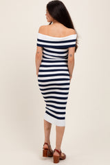 woman wearing a navy and white striped off-the-shoulder maternity dress, showing a baby bump, with a fitted silhouette