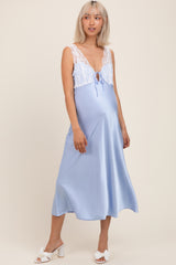woman wearing a light blue lace and satin maternity nightgown with a tied detail and a visible baby bump