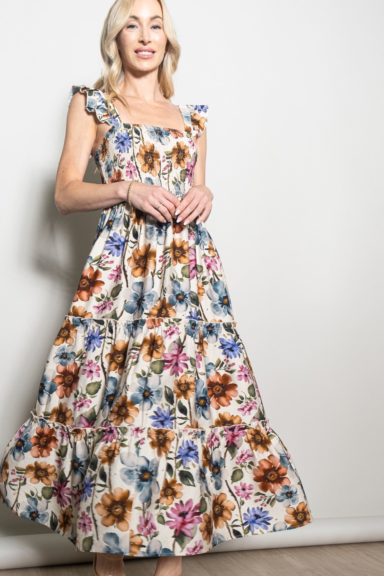 woman wearing a floral print maxi dress with ruffled straps and tiered skirt