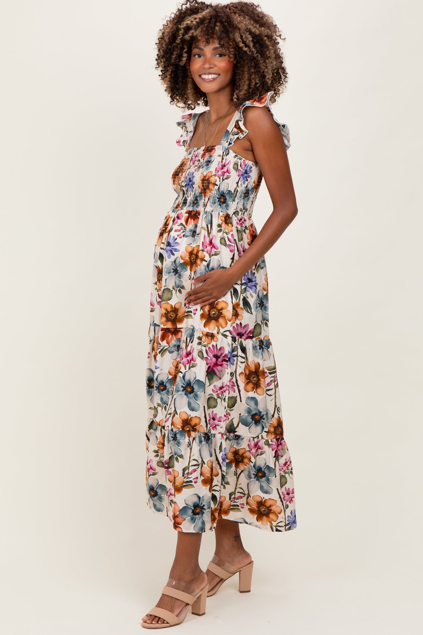 woman wearing a floral print maternity dress with ruffled straps and a visible baby bump