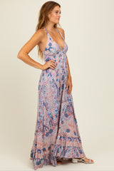 woman wearing a pink floral maxi dress with a halter neckline and ruffle hemline