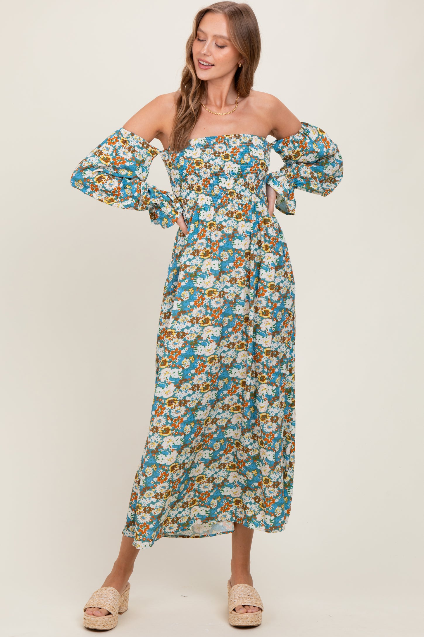 woman wearing a floral off-the-shoulder maxi dress with puff sleeves and a fitted bodice