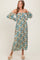 woman wearing a floral off-the-shoulder maxi dress with puff sleeves and a fitted bodice