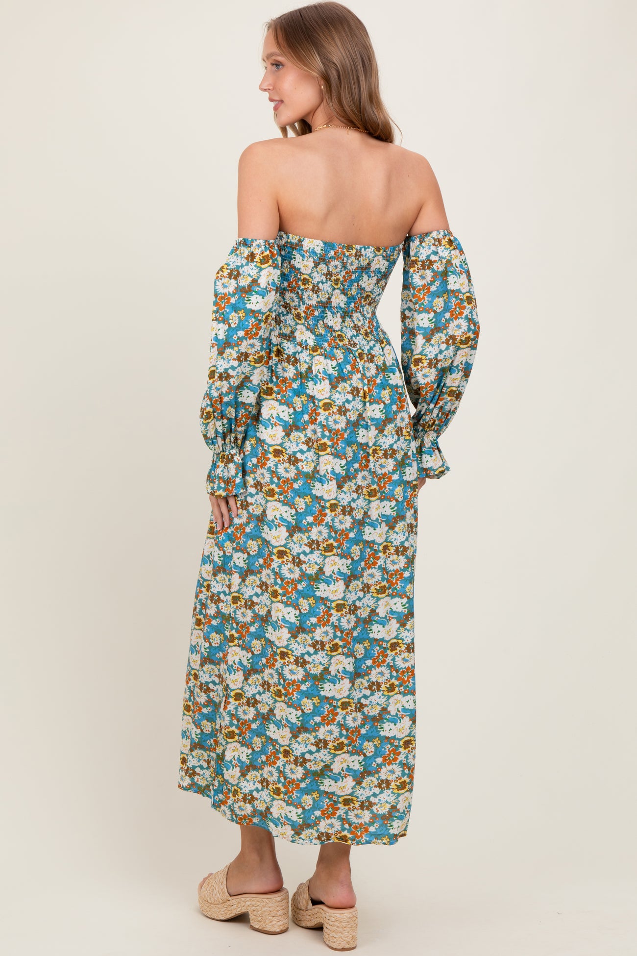 woman wearing a long off-the-shoulder floral maxi dress with puff sleeves and a fitted bodice