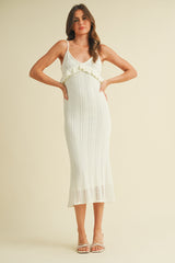 woman wearing a cream knitted midi dress with ruffle detail and spaghetti straps