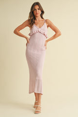 woman wearing a light pink knitted maxi dress with ruffle details and a fitted silhouette