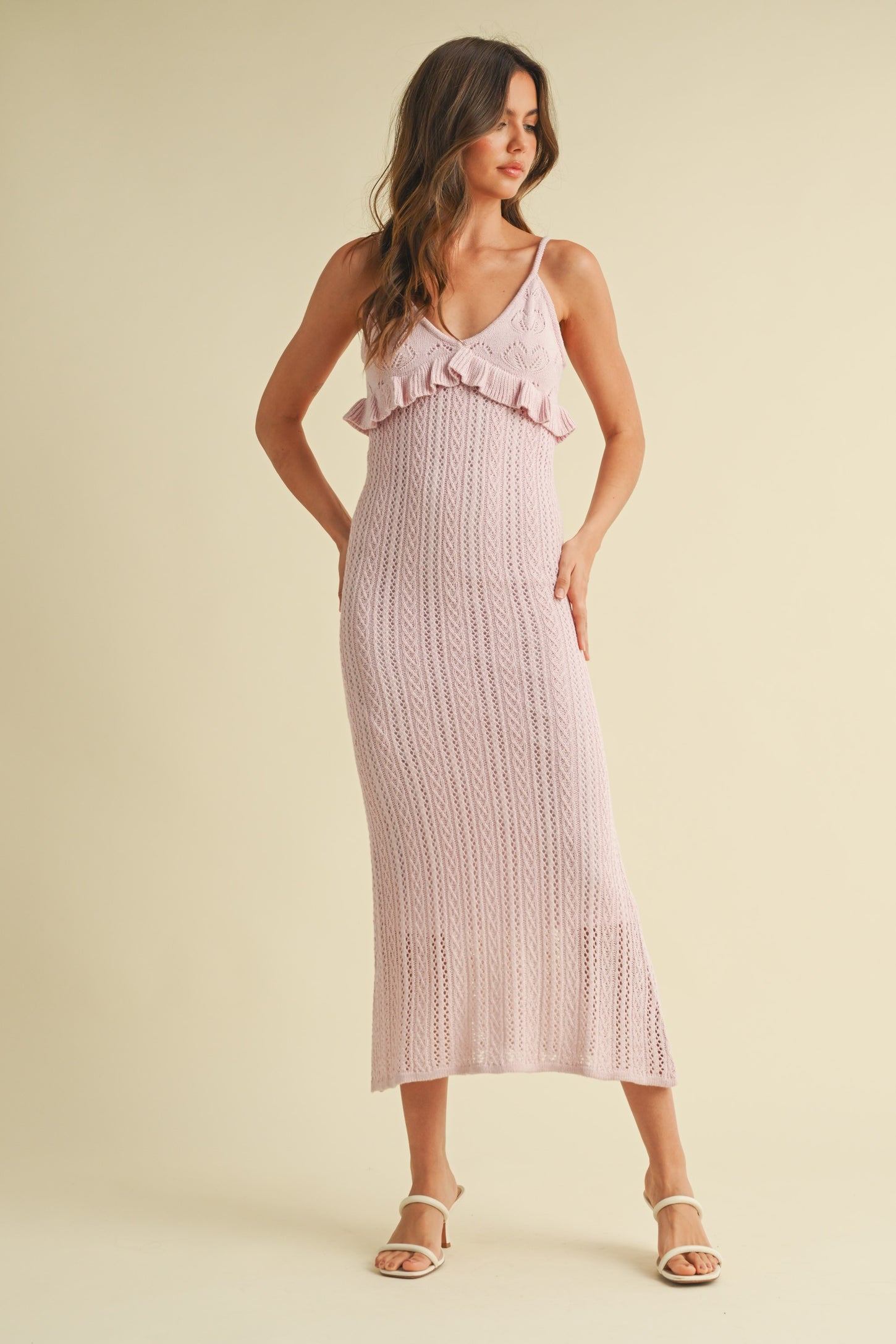 woman wearing a light pink knitted maxi dress with ruffle details and spaghetti straps