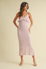 woman wearing a light pink knitted maxi dress with ruffle details and spaghetti straps