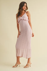 woman wearing a light pink knitted maxi dress with ruffle detailing and a fitted silhouette