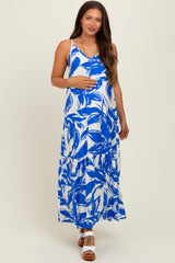 woman wearing a blue and white floral print maternity maxi dress and holding her baby bump